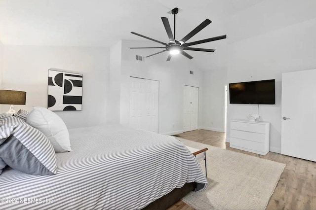 bedroom with lofted ceiling, a closet, light hardwood / wood-style floors, and ceiling fan