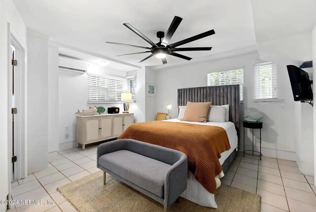 bedroom featuring light tile patterned floors, a wall unit AC, and ceiling fan