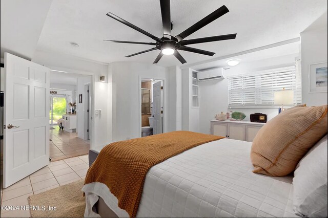 bedroom with ceiling fan, light tile patterned floors, ensuite bath, and a wall mounted air conditioner