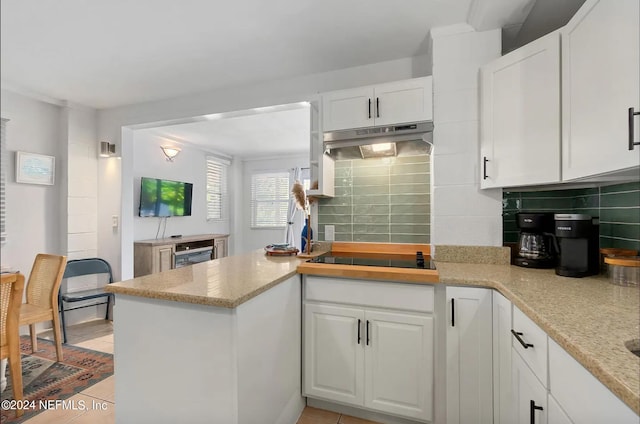 kitchen with black electric cooktop, wine cooler, decorative backsplash, and white cabinetry