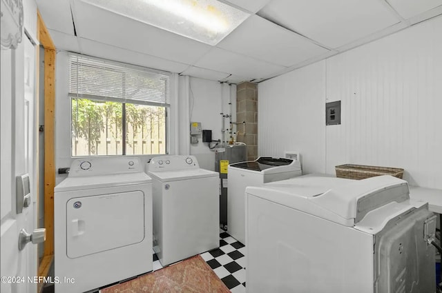 washroom with electric panel, washer and dryer, and electric water heater