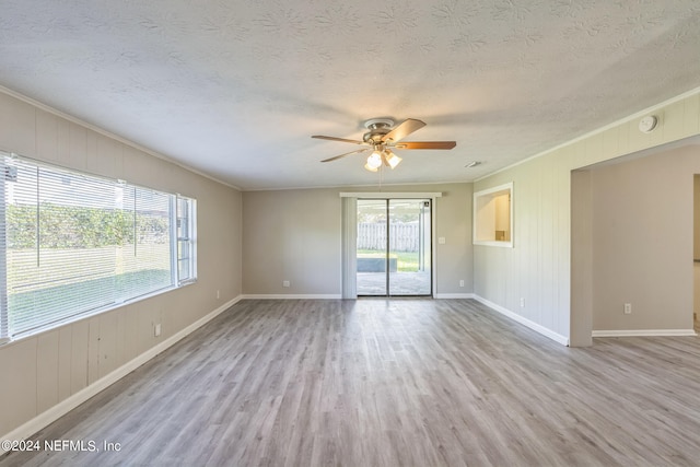 empty room with plenty of natural light, crown molding, light hardwood / wood-style flooring, and ceiling fan