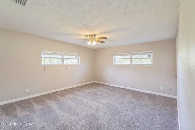 carpeted empty room featuring ceiling fan and a textured ceiling