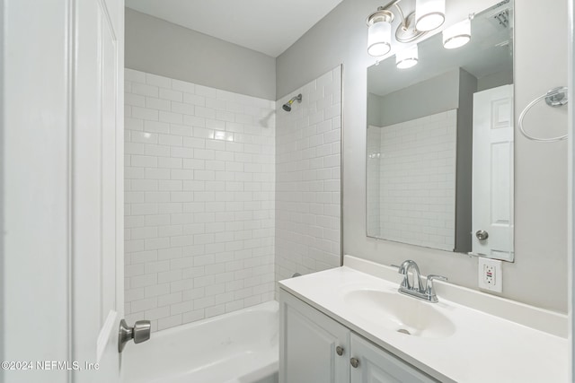 bathroom featuring tiled shower / bath and vanity