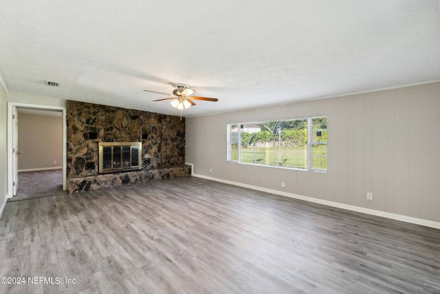 unfurnished living room featuring hardwood / wood-style flooring, a fireplace, ceiling fan, and a textured ceiling