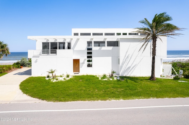 view of front facade featuring a front lawn and a water view