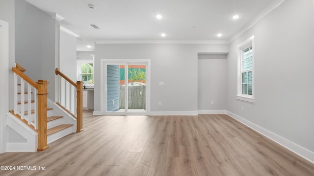 interior space with light wood-type flooring, plenty of natural light, and crown molding