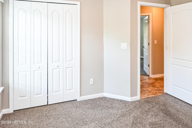 unfurnished bedroom featuring carpet floors and a closet