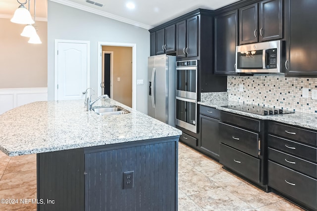 kitchen featuring a center island with sink, backsplash, sink, pendant lighting, and stainless steel appliances