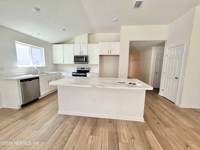 kitchen featuring white cabinets, appliances with stainless steel finishes, light hardwood / wood-style floors, and a center island