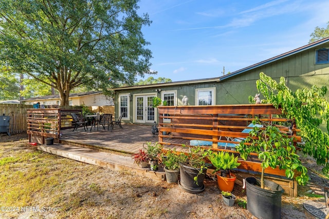 rear view of property featuring a deck and french doors