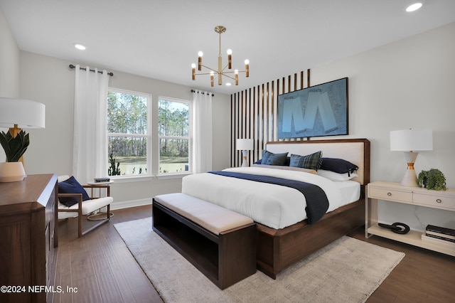 bedroom with dark hardwood / wood-style flooring and a notable chandelier