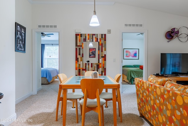 carpeted dining room with ceiling fan and vaulted ceiling