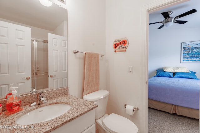 bathroom with ceiling fan, a shower with shower door, vanity, and toilet