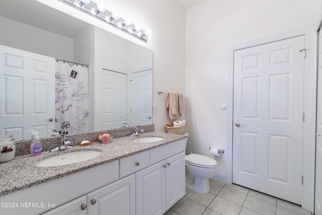 bathroom with tile patterned flooring, vanity, and toilet