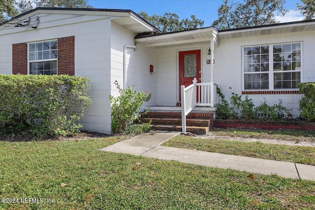 property entrance featuring a lawn