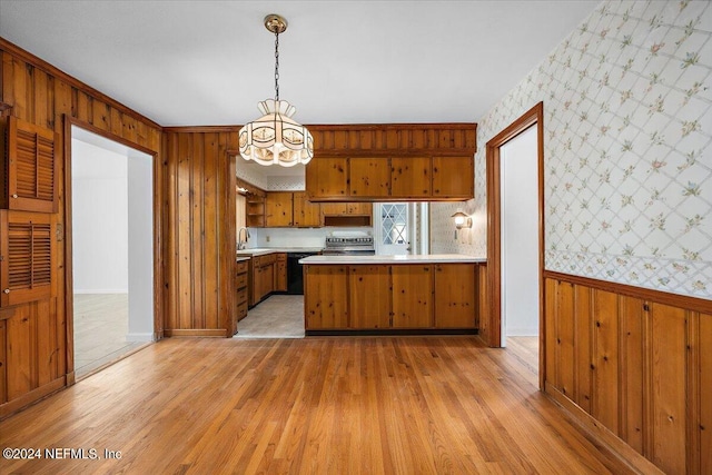 kitchen featuring stainless steel electric stove, light hardwood / wood-style floors, kitchen peninsula, and wooden walls