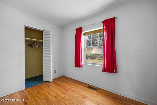 unfurnished bedroom with light hardwood / wood-style flooring and a closet