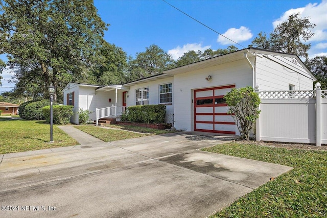 929 Bordeau Ave W, Jacksonville, FL 32211 - view of front of property with a front lawn, a garage, concrete driveway, and fence