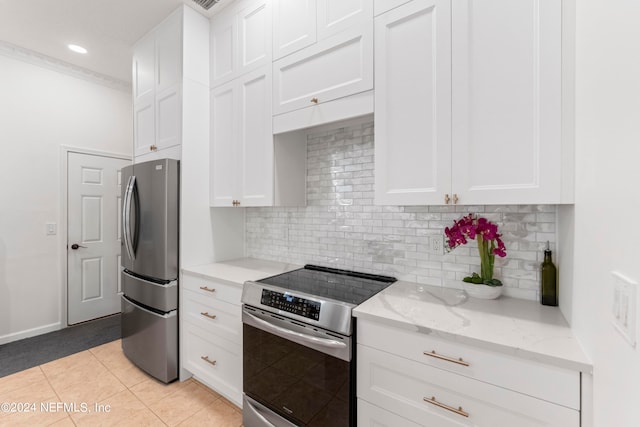 kitchen with stainless steel appliances, light tile patterned floors, decorative backsplash, and white cabinetry