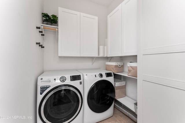 laundry area with cabinets, washing machine and clothes dryer, and light tile patterned floors