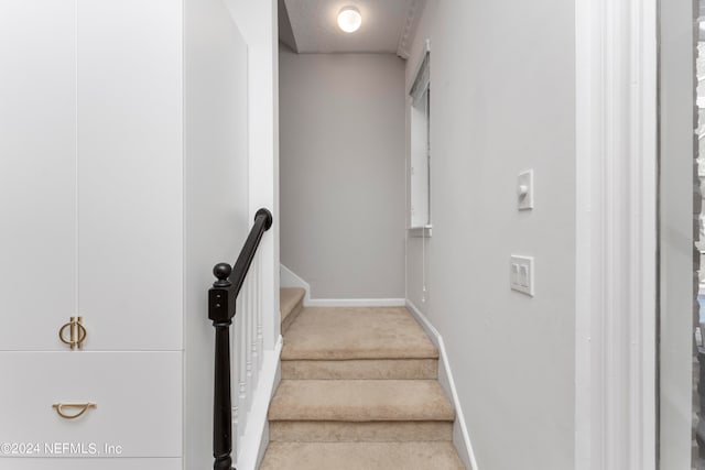 stairs with a textured ceiling