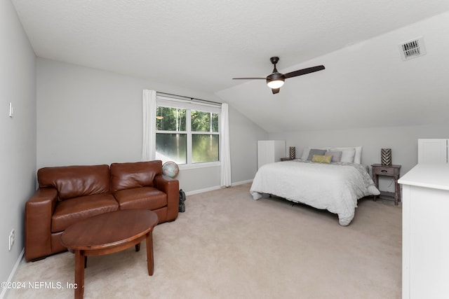 carpeted bedroom featuring vaulted ceiling, a textured ceiling, and ceiling fan