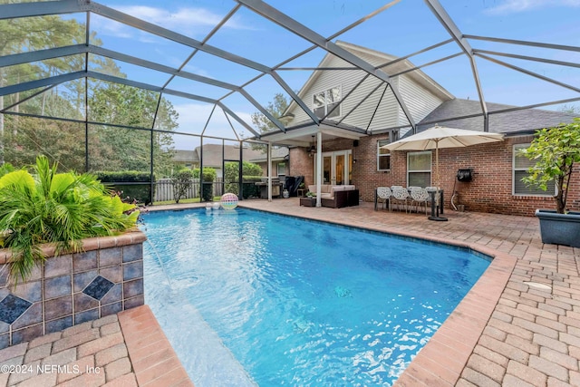 view of swimming pool featuring ceiling fan, an outdoor hangout area, glass enclosure, and a patio