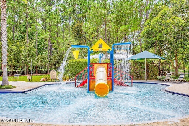 view of swimming pool with pool water feature and a playground