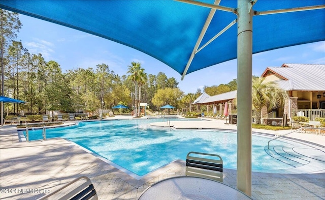 view of pool featuring exterior fireplace and a patio area