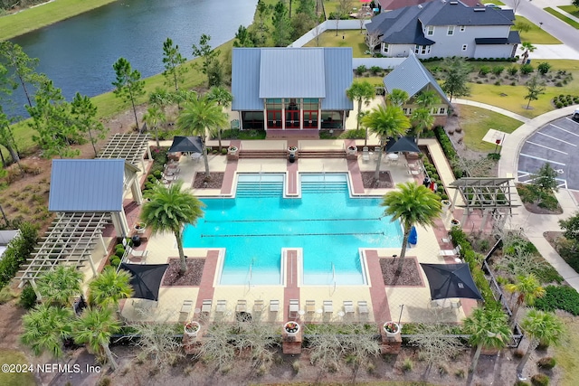 view of swimming pool featuring a patio and a water view