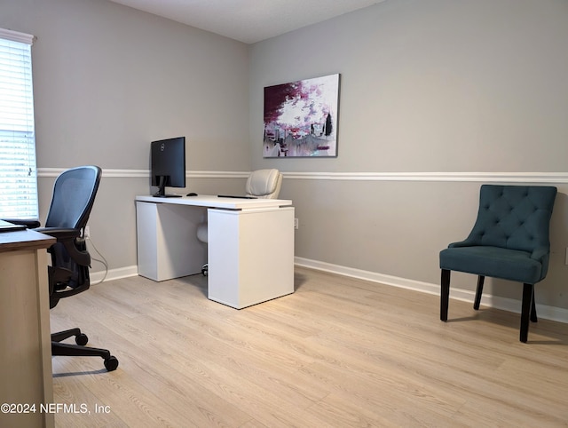 office with light hardwood / wood-style flooring and plenty of natural light