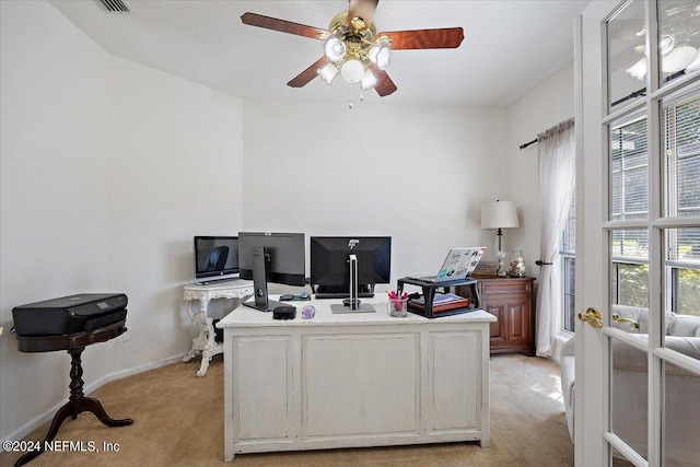 carpeted home office with ceiling fan and a healthy amount of sunlight