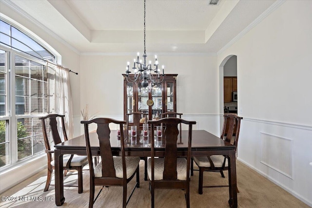 dining room featuring carpet floors, plenty of natural light, ornamental molding, and a tray ceiling