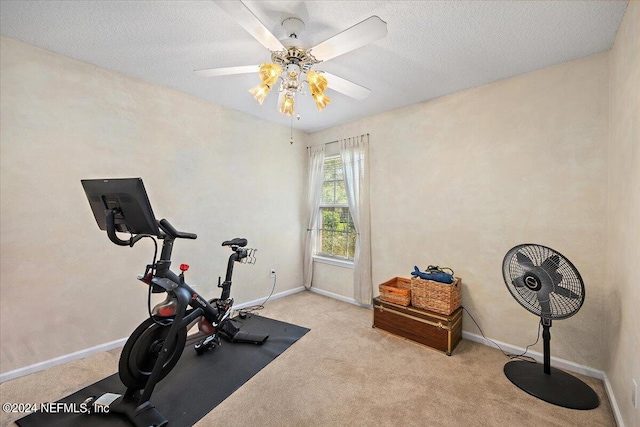 workout room with light carpet, ceiling fan, and a textured ceiling