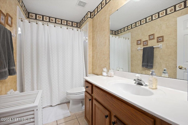 bathroom with vanity, tile patterned flooring, toilet, and a textured ceiling