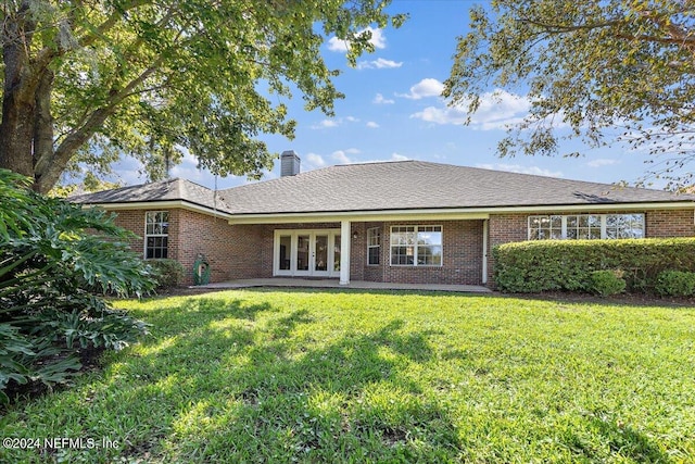 rear view of house featuring french doors and a yard