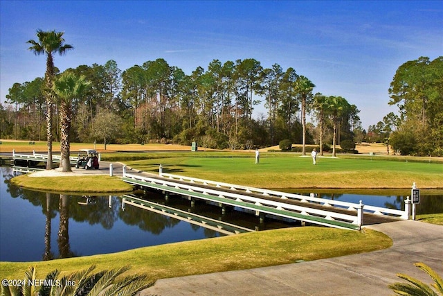 surrounding community featuring a water view and a lawn