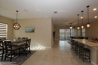 tiled dining room with sink and a notable chandelier