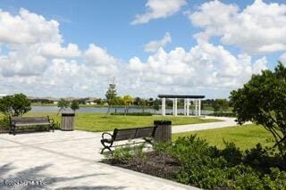 view of home's community featuring a lawn and a water view