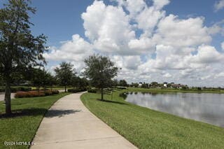 view of home's community featuring a lawn and a water view