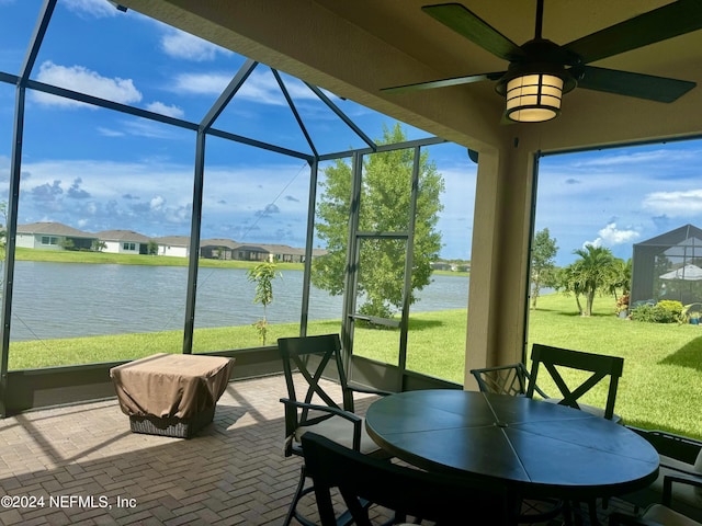 sunroom / solarium featuring a water view and ceiling fan