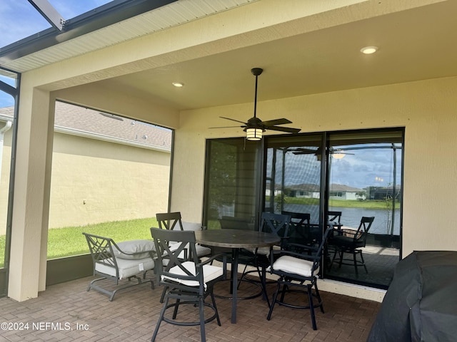 view of patio with a water view and ceiling fan