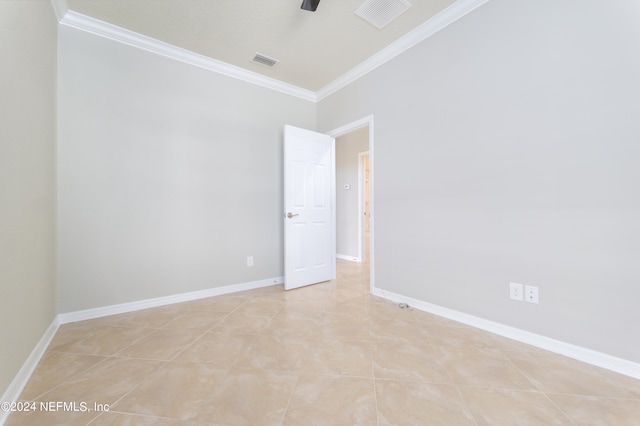 empty room with ornamental molding and light tile patterned floors