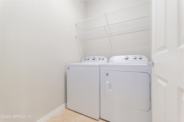 laundry room featuring light tile patterned floors and washing machine and clothes dryer