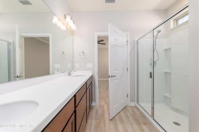 bathroom featuring a shower with shower door, hardwood / wood-style flooring, and vanity