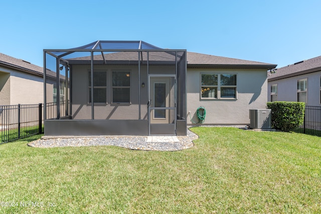 back of house featuring a lanai, cooling unit, and a yard