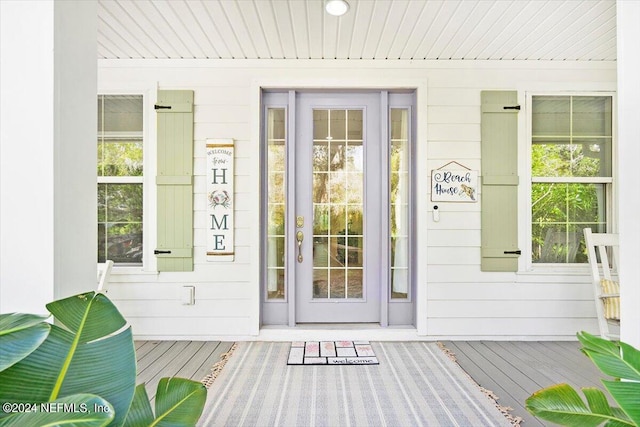 view of exterior entry featuring covered porch