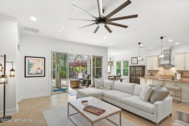 tiled living room with a wealth of natural light, a textured ceiling, and ceiling fan