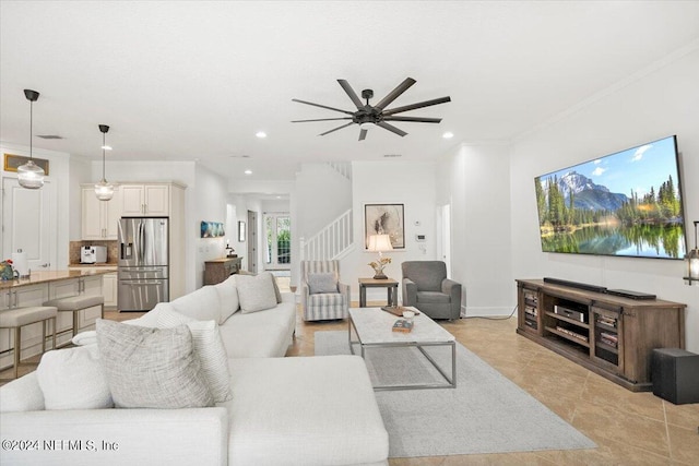 tiled living room featuring ceiling fan and ornamental molding